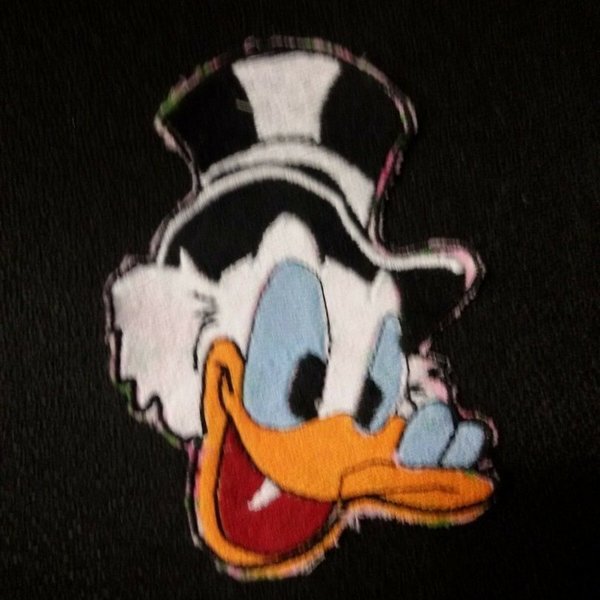 Aufnäher Ente Donald Duck Der Aufnäher ist ein Kopf von Dagobert Duck mit einem schwarzen Zylinder